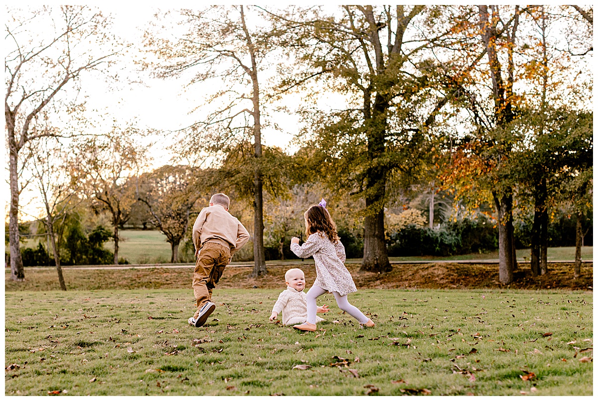 Springville Alabama family photographer_0043 Kids running in field during fall family session at Big Springs Park in Springville, Alabama.
